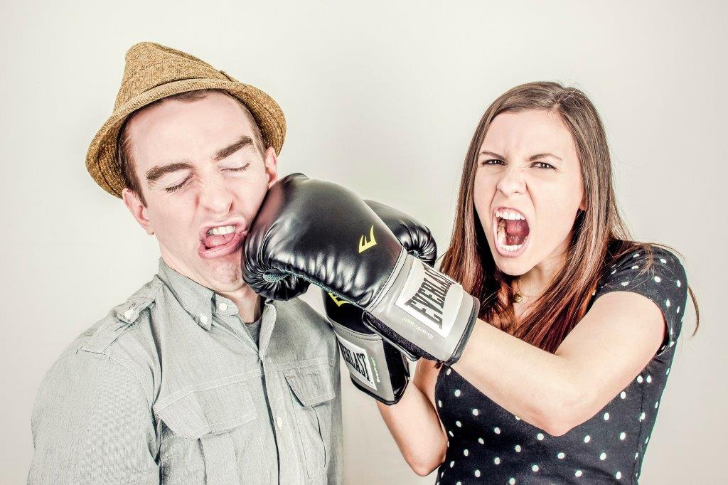 Frau schläft Mann mit Boxhandschuh in das Gesicht